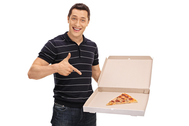 Cheerful guy pointing at a slice of pizza - Zdjęcie, obraz