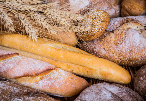 fresh bread and wheat on the wooden - Fotó, kép