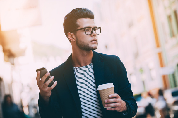 Man holding coffee and smart phone  - 写真・画像