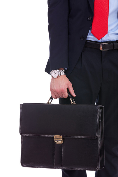 ο άνθρωπος των επιχειρήσεων σε μαύρο κοστούμι χέρι που κρατά το Χαρτοφύλακα - Φωτογραφία, εικόνα