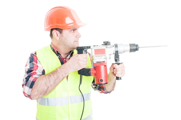 Trabajador con casco sosteniendo la máquina de perforación
 - Foto, imagen