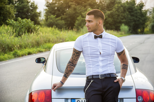 Handsome young man next to car in white shirt - Photo, image