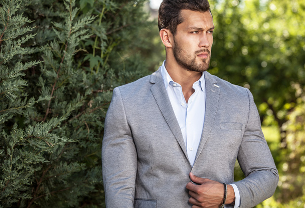 Elegant handsome man in classical jacket poses outdoor - Foto, immagini