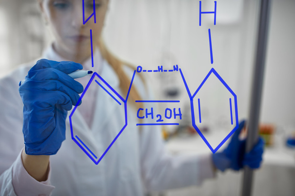 female scientist is drawing chemical reaction on glas - Fotografie, Obrázek