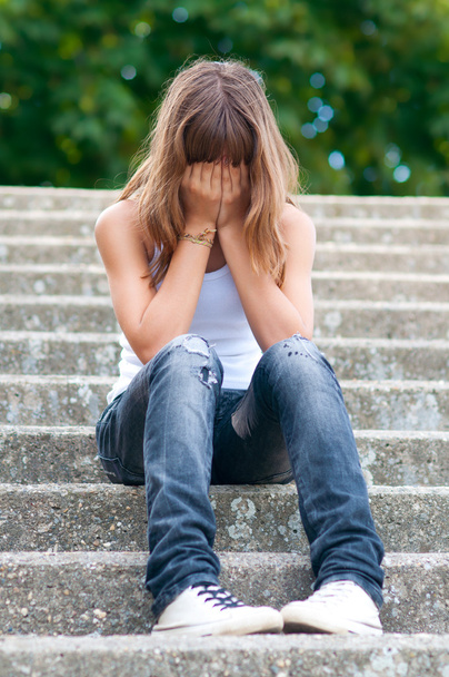 Sad teenage girl sitting alone on the stairs - Fotografie, Obrázek