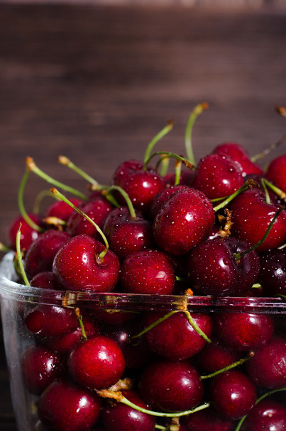 Fresh cherry fruits in a glass on a wooden table. Free space for your text. - Фото, зображення