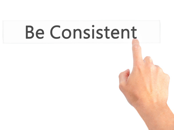 Be Consistent - Hand pressing a button on blurred background con - Photo, Image