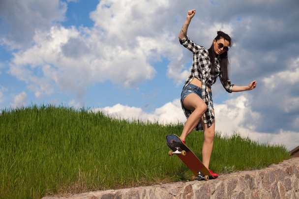 Kobieta robi trick z skate - Zdjęcie, obraz