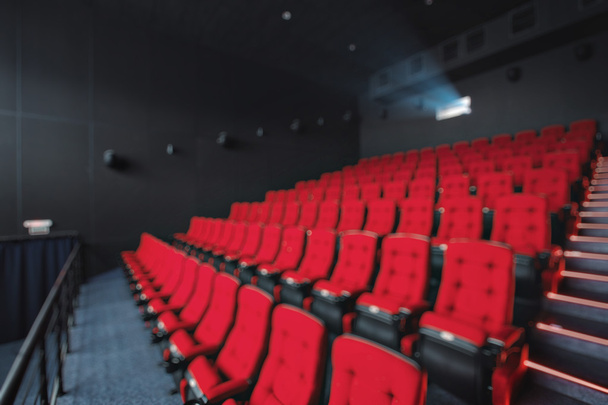 Abstrakte Unschärfen verwischen leere Reihen roter Theater- oder Kinosessel. Stühle im Kinosaal. bequemer Sessel - Foto, Bild