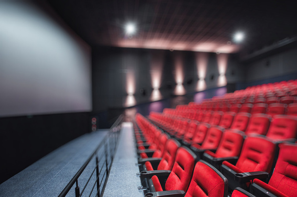 Αφηρημένο θαμπάδα κενές γραμμές από κόκκινο έδρες θέατρο ή τον κινηματογράφο. Καρέκλες στην αίθουσα κινηματογράφου. Άνετη πολυθρόνα - Φωτογραφία, εικόνα
