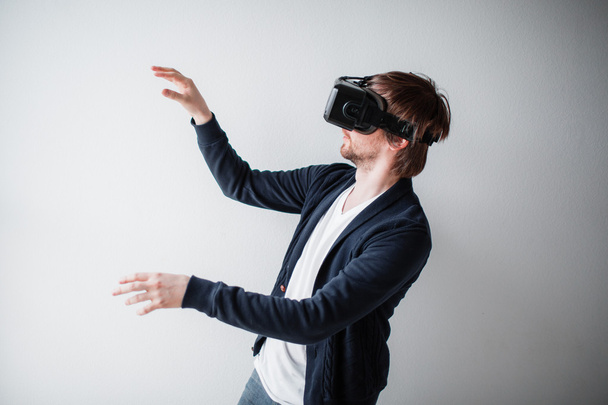 Красивий чоловік у окулярах віртуальної реальності ізольований на сірому фоні
 - Фото, зображення