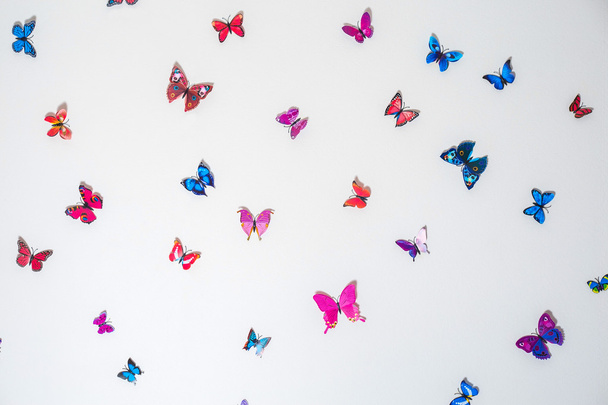 Beautiful artificial butterflies on a white wall background - Foto, Imagem