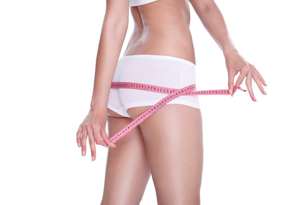 Slim girl measuring her hips - Foto, afbeelding