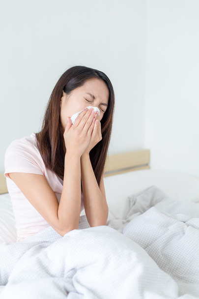 mujer estornudando en la cama
 - Foto, imagen