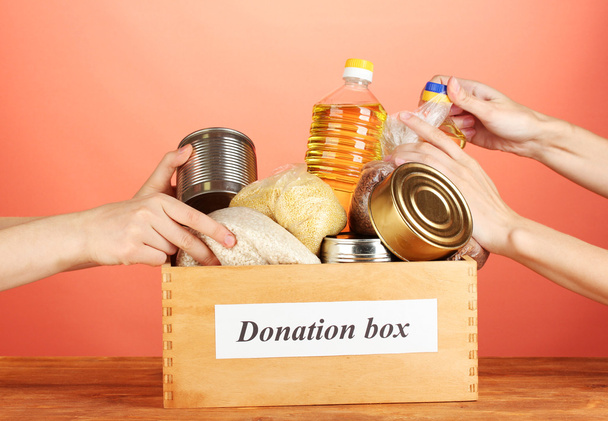Donation box with food on red background close-up - Foto, imagen