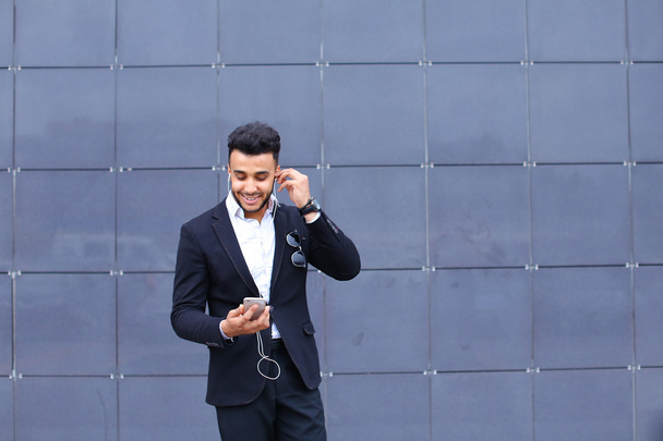 Przystojny mężczyzna arabski przyjmuje selfie inteligentny telefon w centrum biznesowe - Zdjęcie, obraz