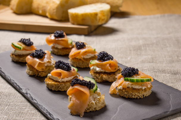 Canapés de salmón ahumado con crema agria y caviar
 - Foto, Imagen