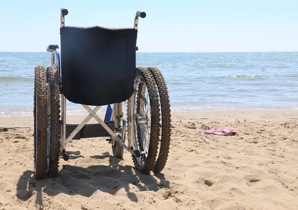 fauteuil roulant sur la plage au bord de la mer
 - Photo, image