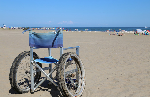 інвалідне крісло алюміній на піску пляжу
 - Фото, зображення
