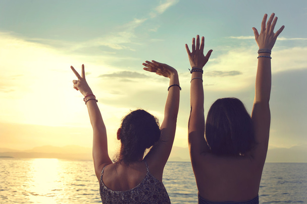 young women opened her hands at sunset at sea on vacation - Foto, Imagen
