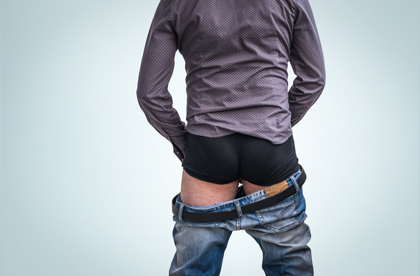 Standing man has undress jeans and peeing - 写真・画像