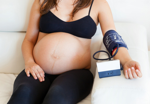 Mujer embarazada mide la presión arterial
 - Foto, imagen