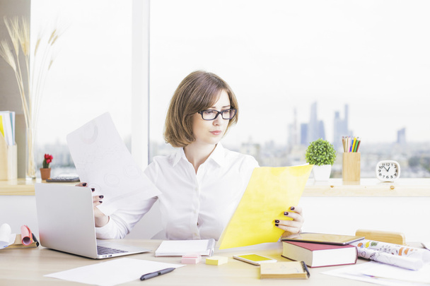 Woman in office doing paperwork - Фото, изображение