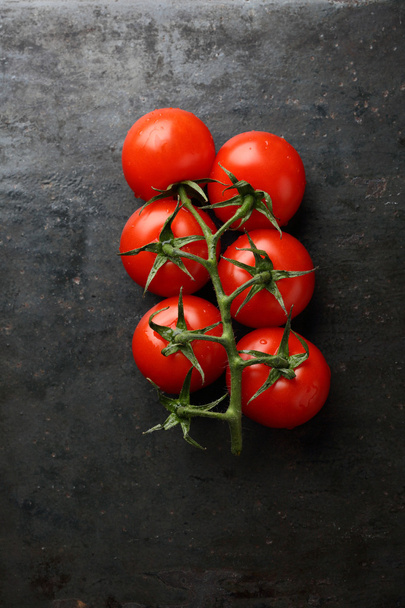 Branch of fresh tomatoes on slate - Фото, зображення