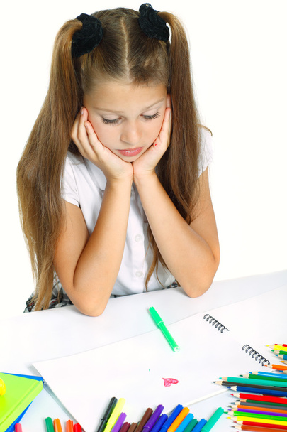 A beautiful girl in a school form drawing a marker, isolated on a white background - Foto, Imagen