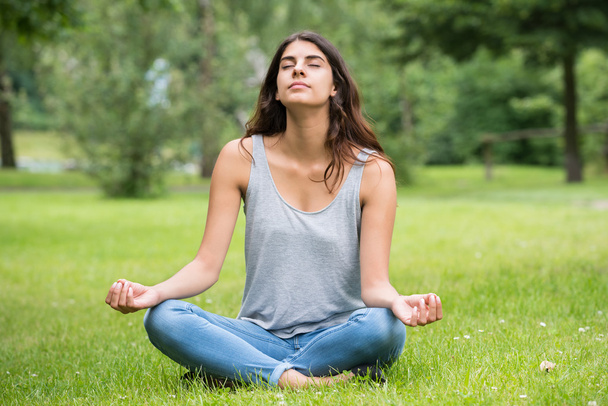 Woman Doing Meditation In Park - Foto, afbeelding