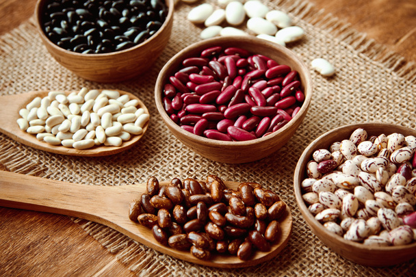 Beautiful multi-colored beans in ceramic bowls on a background of burlap - Φωτογραφία, εικόνα