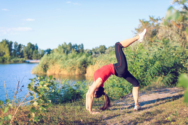 Young girl doing yoga in the park - Valokuva, kuva