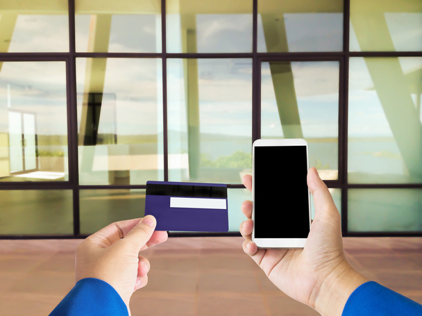 Izolované ruka s kreditní nebo debetní platební karta a chytrý telefon nebo m - Fotografie, Obrázek