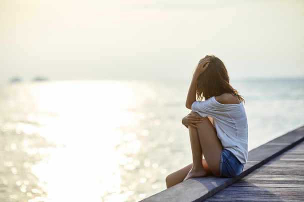 Young beautiful woman sitting on pier  - Foto, Imagen