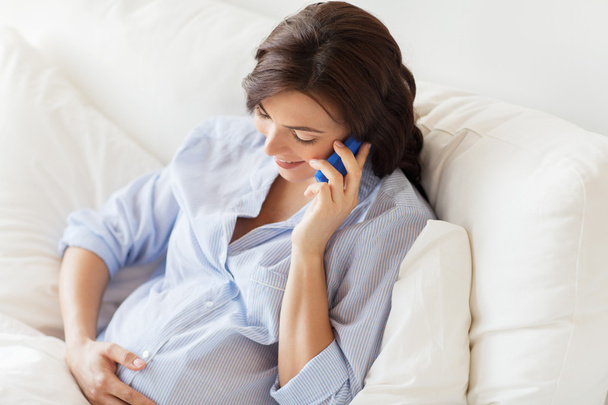 ευτυχισμένη έγκυος γυναίκα καλώντας στο smartphone στο σπίτι - Φωτογραφία, εικόνα