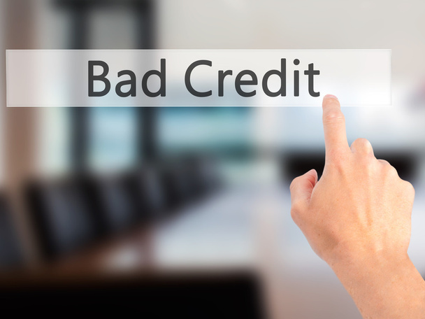 Slecht krediet - Hand indrukken van een knop op de onscherpe achtergrond concep - Foto, afbeelding