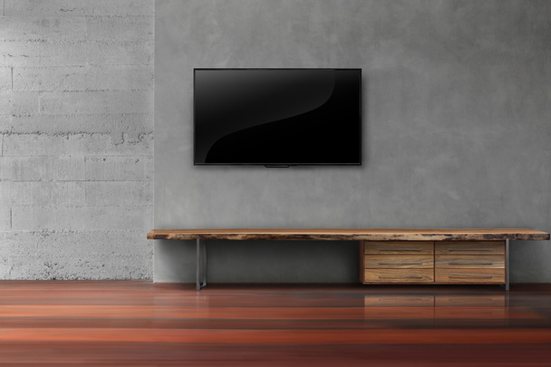 Led tvs en la pared de hormigón con muebles de madera en el salón vacío r
 - Foto, Imagen