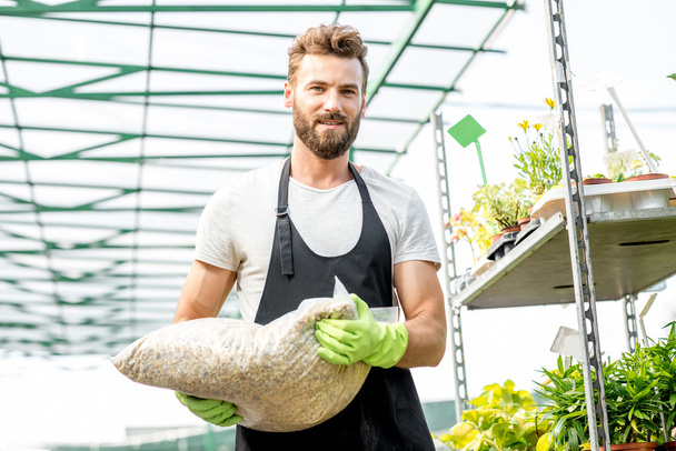 Handsome gardener with bag of soil - Foto, Bild