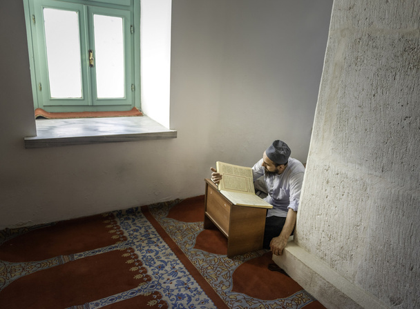 Muslime lesen das Qr 'an allein in der Moschee - Foto, Bild