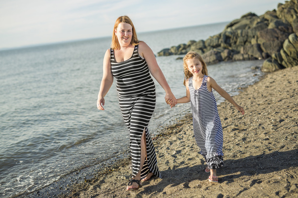 Mother and daughter on the beach side having fun - Photo, Image