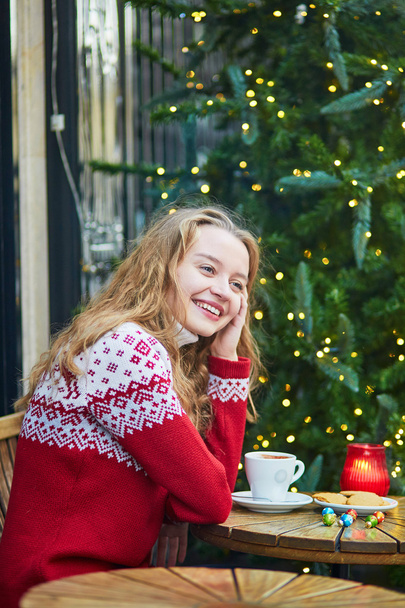 Young woman on a street of Paris decorated for Christmas - Foto, Bild