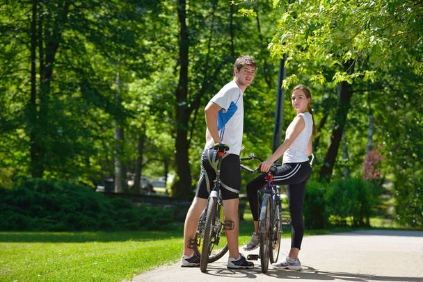 Happy couple riding bicycle outdoors - Fotó, kép