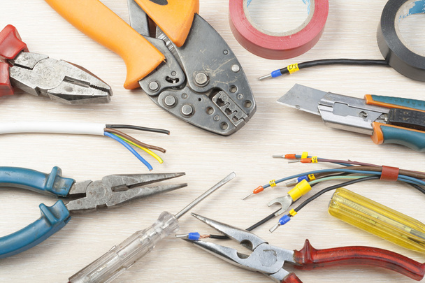Set of electrical tool on wooden background. Accessories for engineering work, energy concept. - 写真・画像