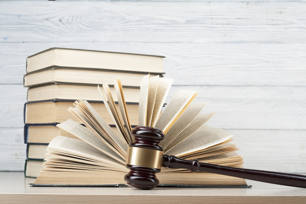 Law concept - Book with wooden judges gavel on table in a courtroom or enforcement office. - Foto, Imagen