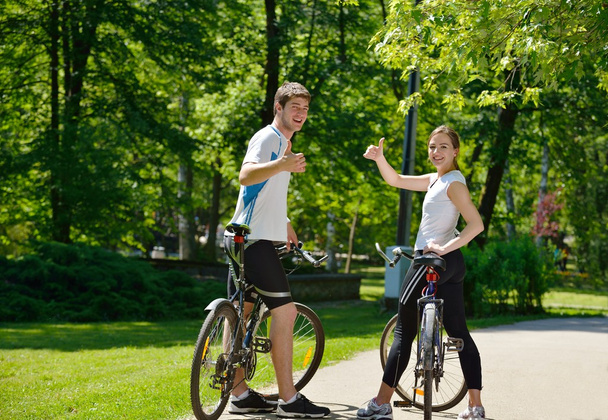 Happy couple riding bicycle outdoors - Фото, зображення