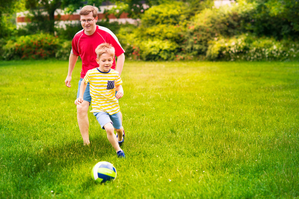 Happy family plays football in sunny park - Fotografie, Obrázek