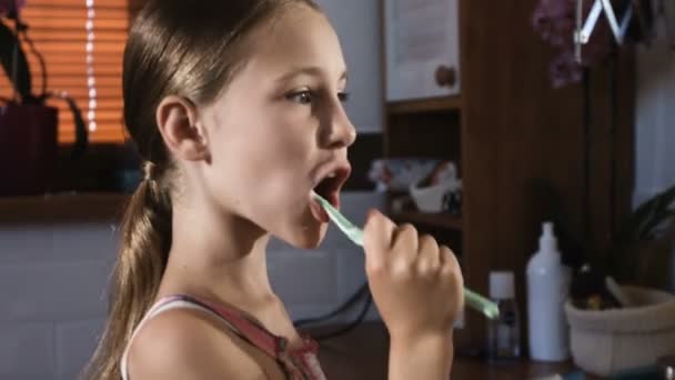 Kind meisje in roze pyjama wassen en poetsen van de tanden in de badkamer - Video