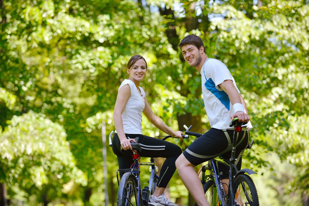 Happy couple riding bicycle outdoors - Zdjęcie, obraz