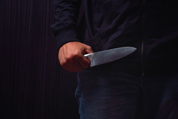 Closeup of a young man hand, holding a knife, about to attack, o - 写真・画像