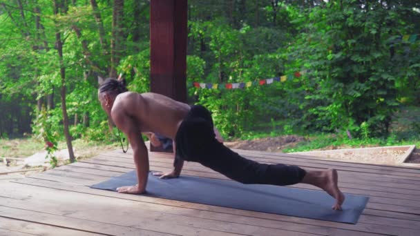 L'uomo esegue esercizi di yoga, sollevando una gamba e piegando l'altra
. - Filmati, video